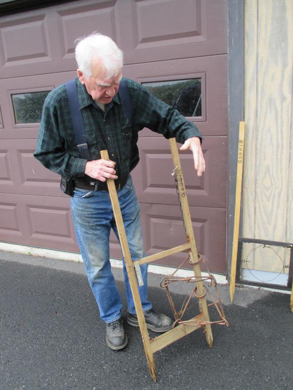 Demonstrating the workings of a beaver trap, Oscar Cronk, the well known hunter, trapper and scent maker, will celebrate his 85th birthday next month but has no plans to retire. PHIL DI VECE/Wiscasset Newspaper Cronk