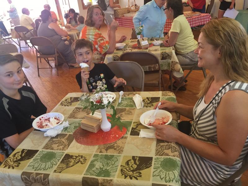Aidan Drage, left, brother Ronan Drage and their mother Tanya Hammond enjoy St. Philip’s Episcopal Church’s strawberry festival June 25. SUSAN JOHNS/Wiscasset Newspaper