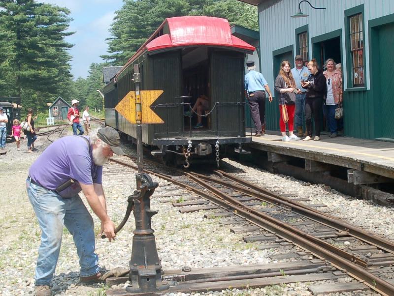 A WW&F volunteer switches rails as riders board the train. ART MAYERS/Wiscasset Newspaper