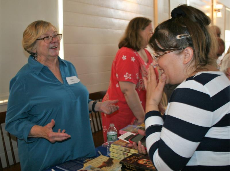 Mystery writer Lea Wait and a fan share a laugh at the Books in Boothbay event July 14. LISA KRISTOFF/Boothbay Register