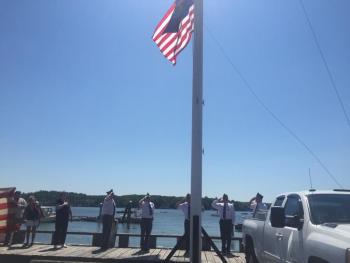 American Legion Post 54 members salute at a flag-raising on the waterfront. SUSAN JOHNS/Wiscasset Newspaper