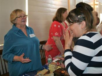 Mystery writer Lea Wait and a fan share a laugh at the Books in Boothbay event July 14. LISA KRISTOFF/Boothbay Register