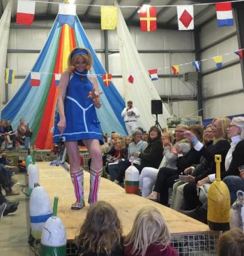Calypso model Kathleen Sheehan Viens waves to the three little girls at the foot of the runway The brightly colored boots are by Susan Brackett. LISA KRISTOFF/Boothaby Register
