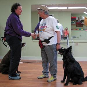 Dog trainer Jean Conte, holding the leash of a Canine Good Citizen and his or her human. Courtesy of Marianne Pinkham Dog trainer Jean Conte (white shirt)
