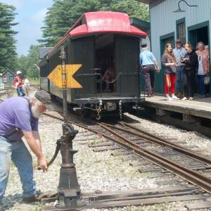 A WW&F volunteer switches rails as riders board the train. ART MAYERS/Wiscasset Newspaper
